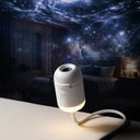 White gooseneck USB galaxy projector on a nightstand casting a galaxy across the ceiling