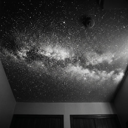 Bedroom ceiling covered in a black-and-white Milky Way projection